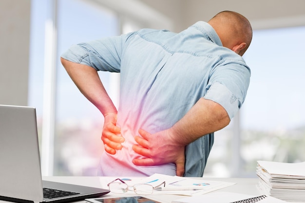 Business man with back pain an office . Pain relief concept