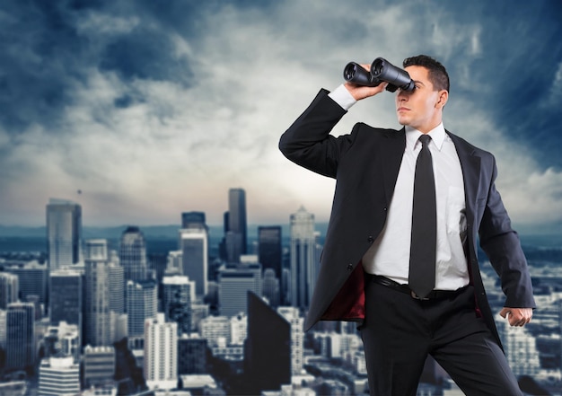 Photo business man with binoculars spying on competitors