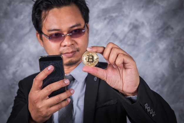 business man with bitcoin and using mobile phone