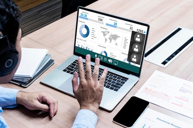 Business man with headphone looking to display laptop and raise hand greeting online meeting