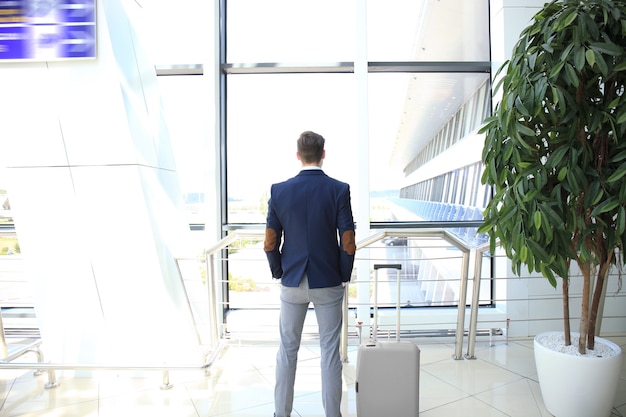 Business man with suitcase in hall of airport.