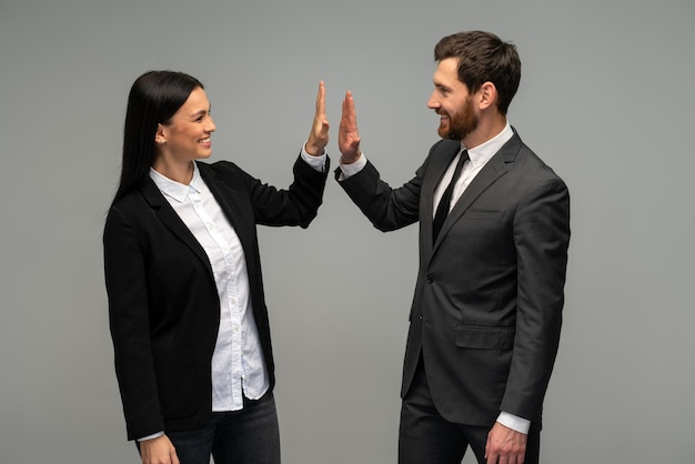 Uomo d'affari e donna che danno ciao cinque e urtano insieme la mano per il lavoro di squadra concetto di team aziendale di diversità