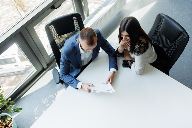 Business man and woman having a meeting and analyzing documents for a future deal