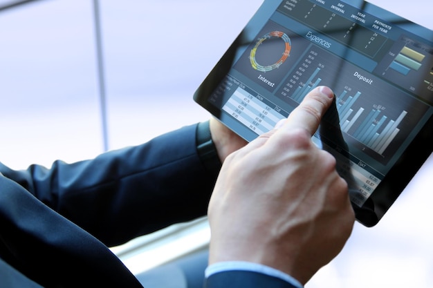 business man working and analyzing financial figures on a graphs on a tablet