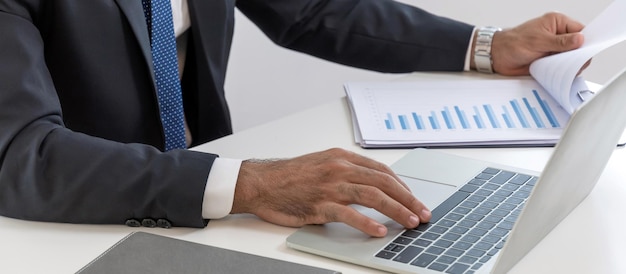 Photo business man working and calculating about finance with document report and digital laptop computer on desk at home office digital online marketing and financial business technology concept