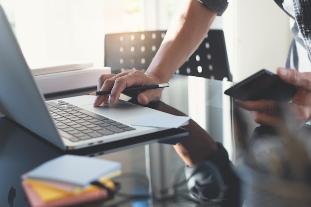 Uomo d'affari che lavora su un computer portatile e utilizza il telefono cellulare a casa