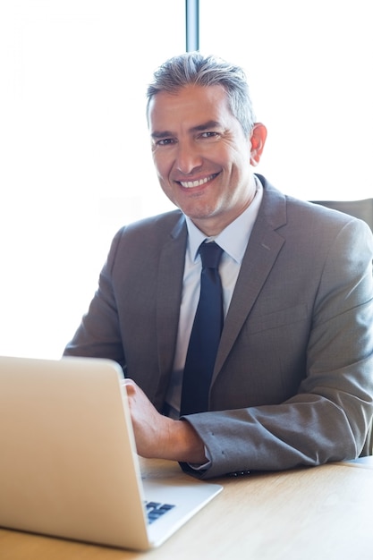 Деловой человек работает на ноутбуке в конференц-зале во время встречи в офисе