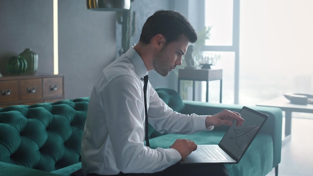 Деловой человек работает на ноутбуке в офисе Менеджер смотрит на графики на компьютере