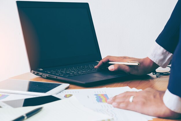 Business man working at office with laptop and documents on his desk