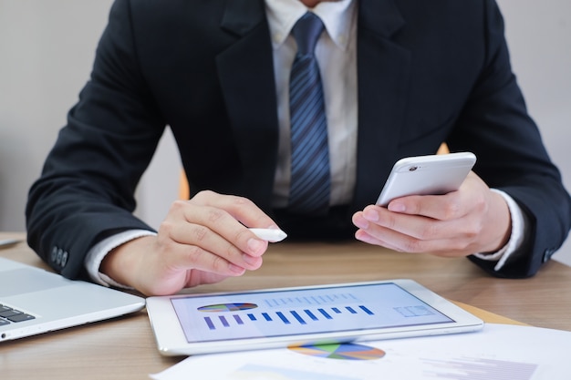 business man working on tablet  pad and smartphone and laptop on desk