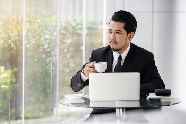 Business man working with laptop and drinking a cup of coffee 