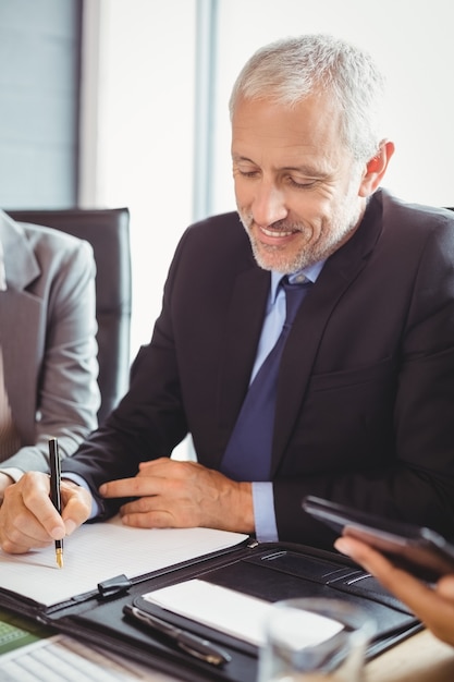 business man writing a report in conference room