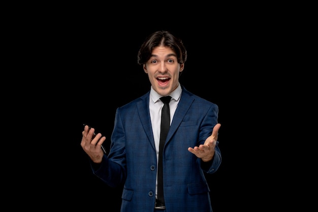 Business man young excited handsome man in dark blue suit with the tie holding phone