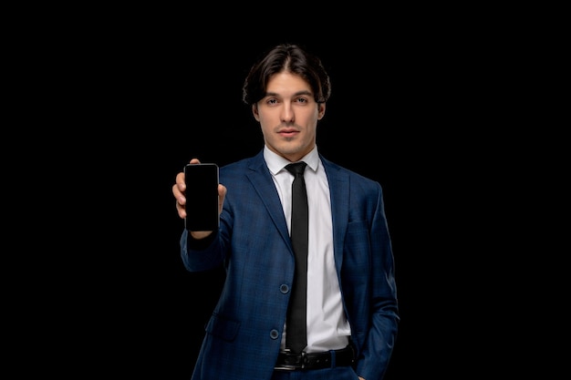 Business man young handsome guy in dark blue suit with the tie holding phone
