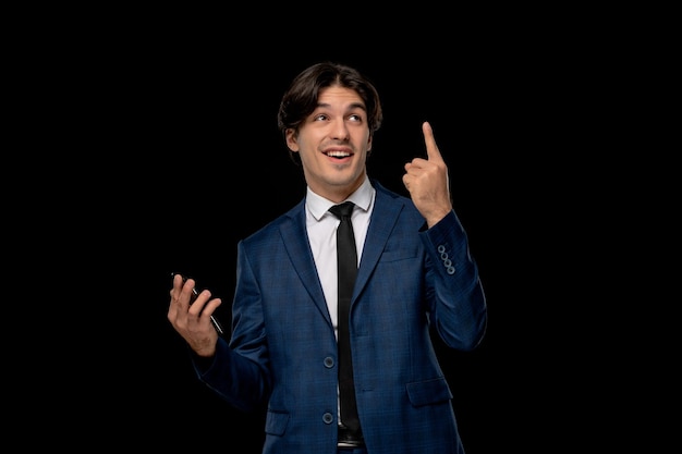 Business man young handsome man in dark blue suit with the tie smiling and holding phone