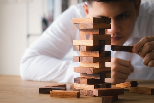 Photo business management concepts and business strategies executive hands pulling out wooden blocks expressing corporate vision preventing risks from future crises