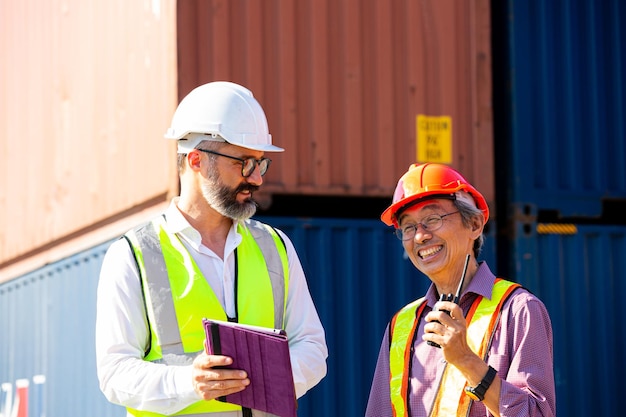 La gestione aziendale discute con il caposquadra per la comunicazione prima del carico della nave container al cliente. carico internazionale per la distribuzione al magazzino.