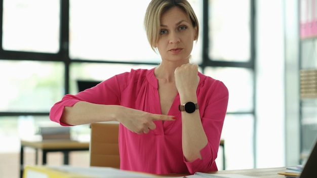 Business manager points to the clock at workplace