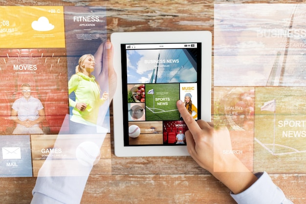 business, mass media, people and technology concept - close up of female hands pointing finger to news application on tablet pc computer screen