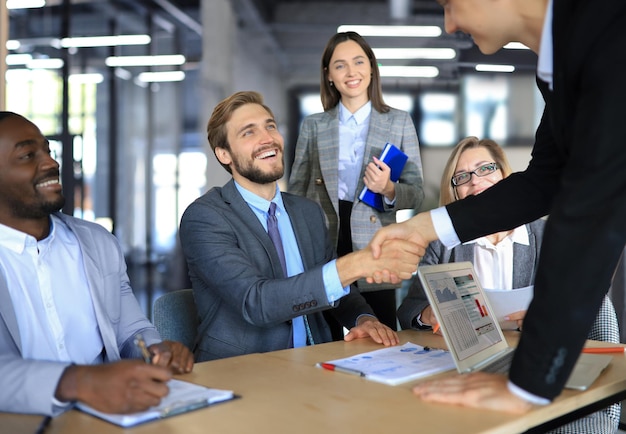 Business meeting associates shaking hands in office