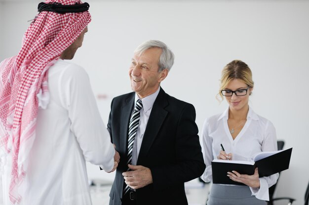 Business meeting - Handsome young Arabic  man presenting his ideas to colleagues and listening for ideas for success investments at bright modern office room