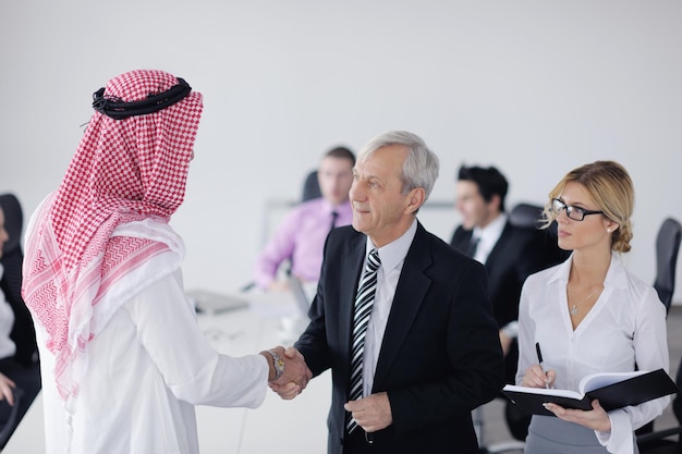 Business meeting - Handsome young Arabic  man presenting his ideas to colleagues and listening for ideas for success investments at bright modern office room