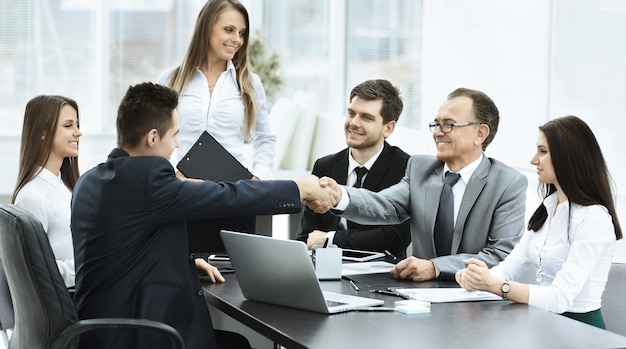 Business meeting at the table and handshake of business partners