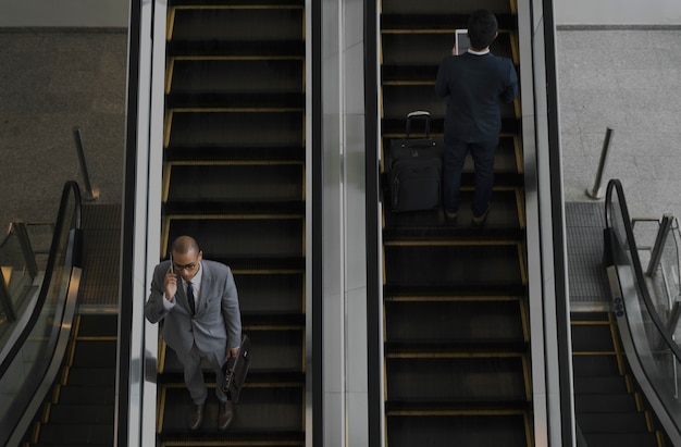 Photo business men escalator talk mobile