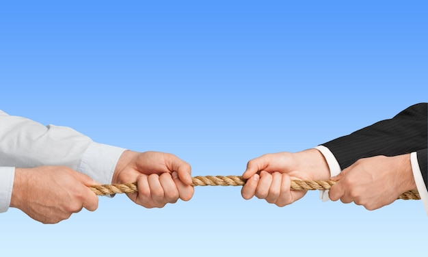 Business men hands holding rope on background