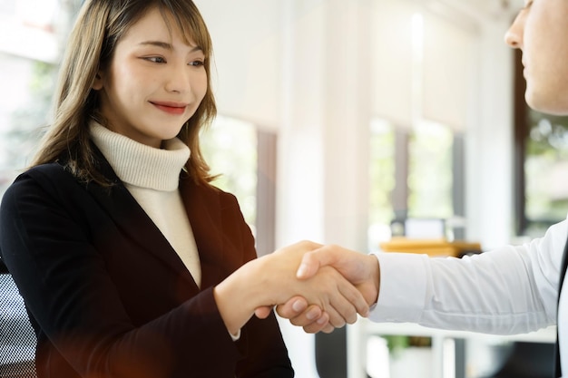 Business men and women shake hands confidently at an office meeting