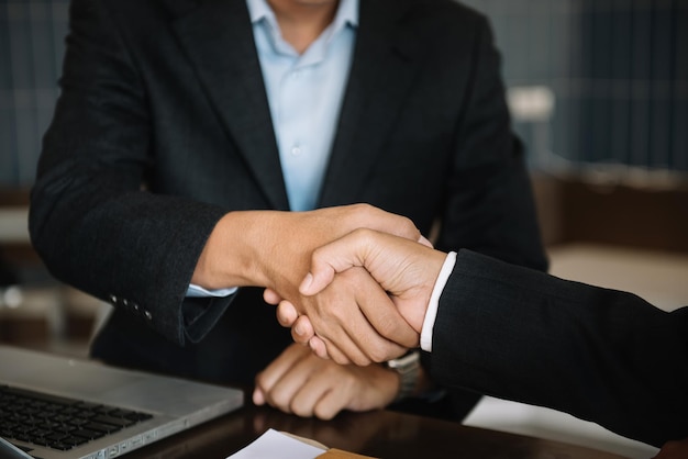 Business men and women shake hands confidently professional\
investor working with new startup project at an office meeting