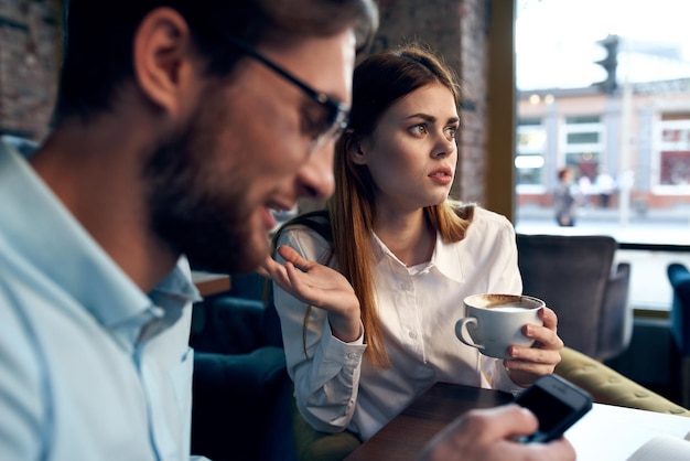 Business men and women sit at the table with the phone chatting breakfast High quality photo