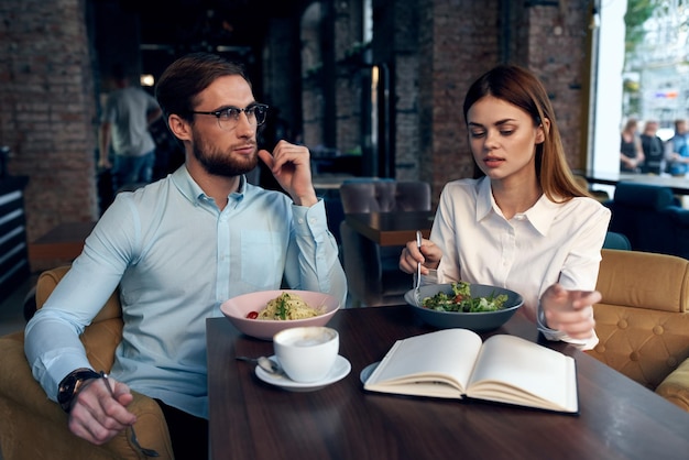 비즈니스 남성과 여성은 아침 식사를 채팅 전화로 테이블에 앉아