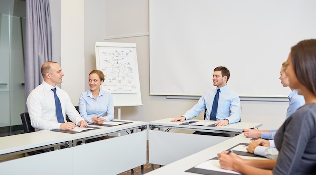 business, mensen en teamwork concept - groep lachende zakenmensen ontmoeten elkaar op kantoor