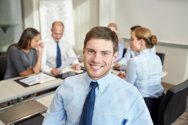 business, mensen en teamwork concept - lachende zakenman met een groep zakenmensen die op kantoor bijeenkomen