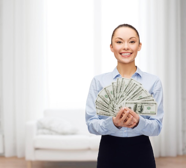 концепция бизнеса и денег - молодая деловая женщина с долларовыми наличными деньгами