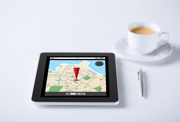 business, navigation, location and technology concept - tablet pc computer with gps navigator map and cup of coffee