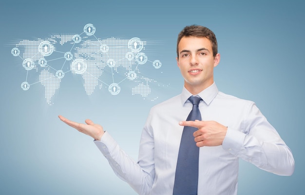 business and office, advertising, people concept - friendly young buisnessman showing map and network on the palm of his hand