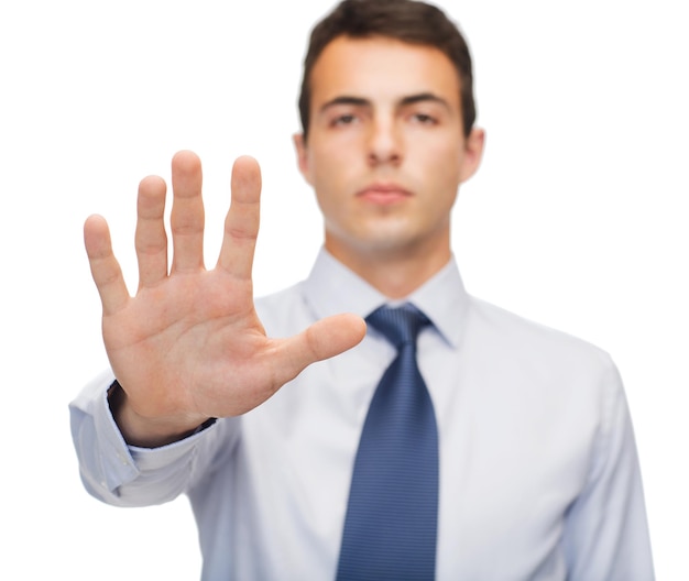 business and office, ban, veto, warning concept - attractive buisnessman making stop gesture