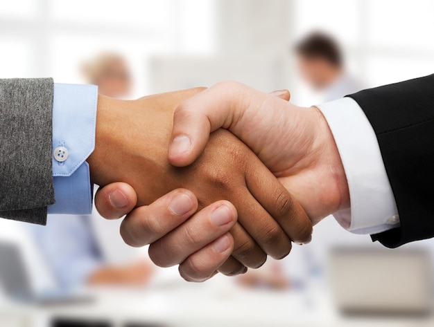 business and office concept - businessman and businesswoman shaking hands in office