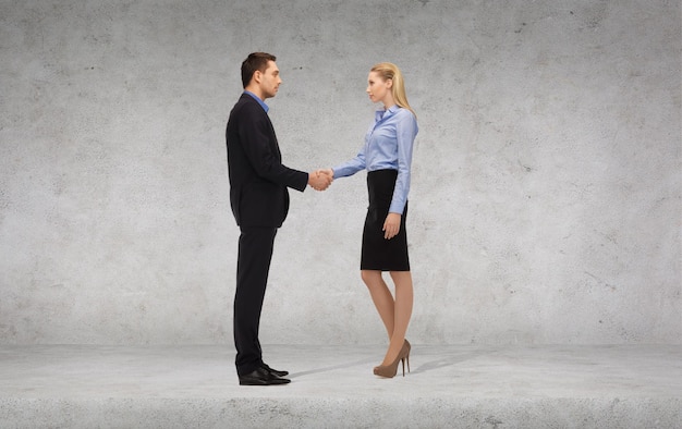 business and office concept - businessman and businesswoman shaking hands