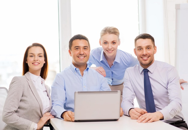 business and office concept - smiling business team working with laptop computer in office