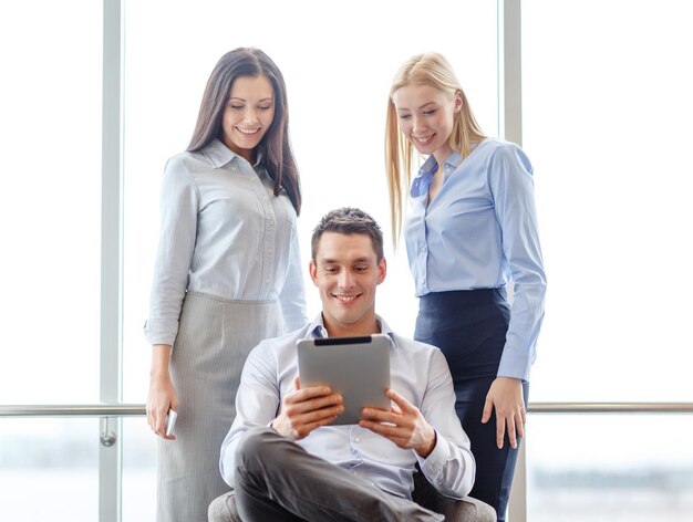 business and office concept - smiling business team working with tablet pc in office