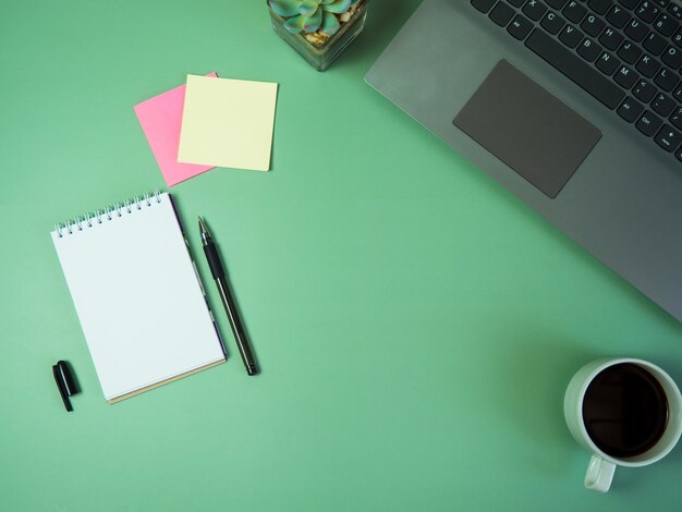 Photo business office desk concept ideas top view with laptops coffee and stickers on green table copy space