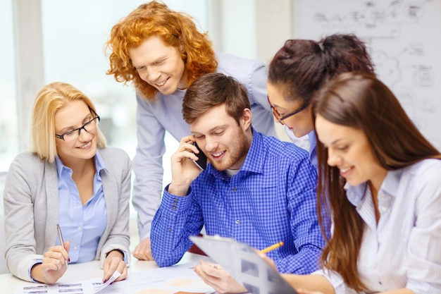 business, office, technology and startup concept - creative team with papers and clipboard working at office