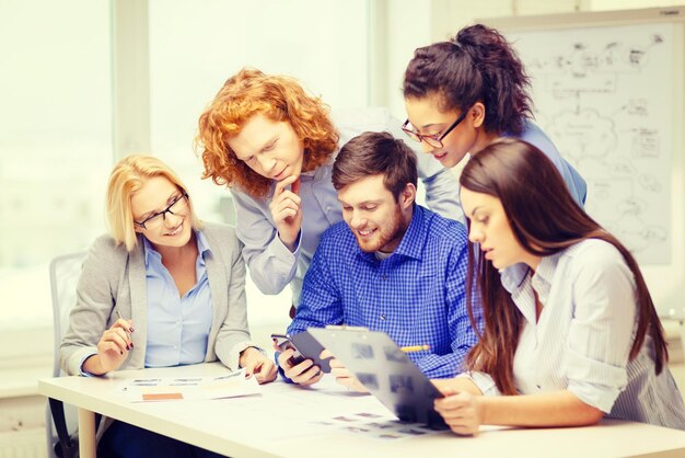 business, office, technology and startup concept - creative team with papers and clipboard working at office