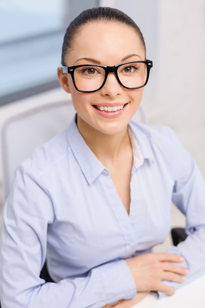 business, office and vision concept - smiling businesswoman in eyeglasses in office