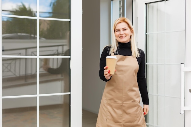 Business Owner Concept - Mooie Kaukasische Barista biedt warme koffie in de moderne coffeeshop