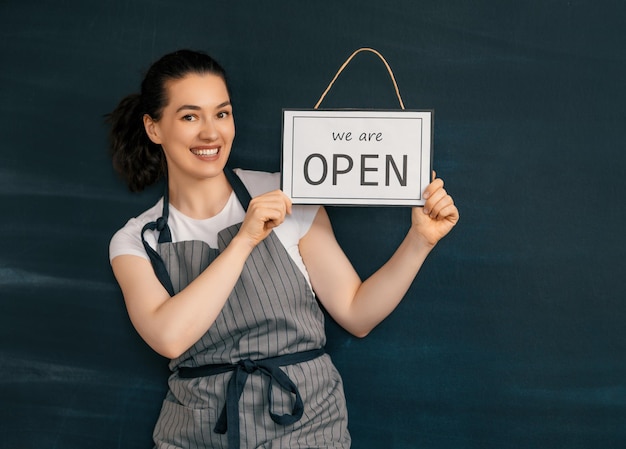 Business owner holding the sign for the reopening