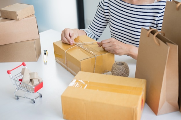 Business owner woman working online shopping prepare product packaging process at her home, young entrepreneur concept.